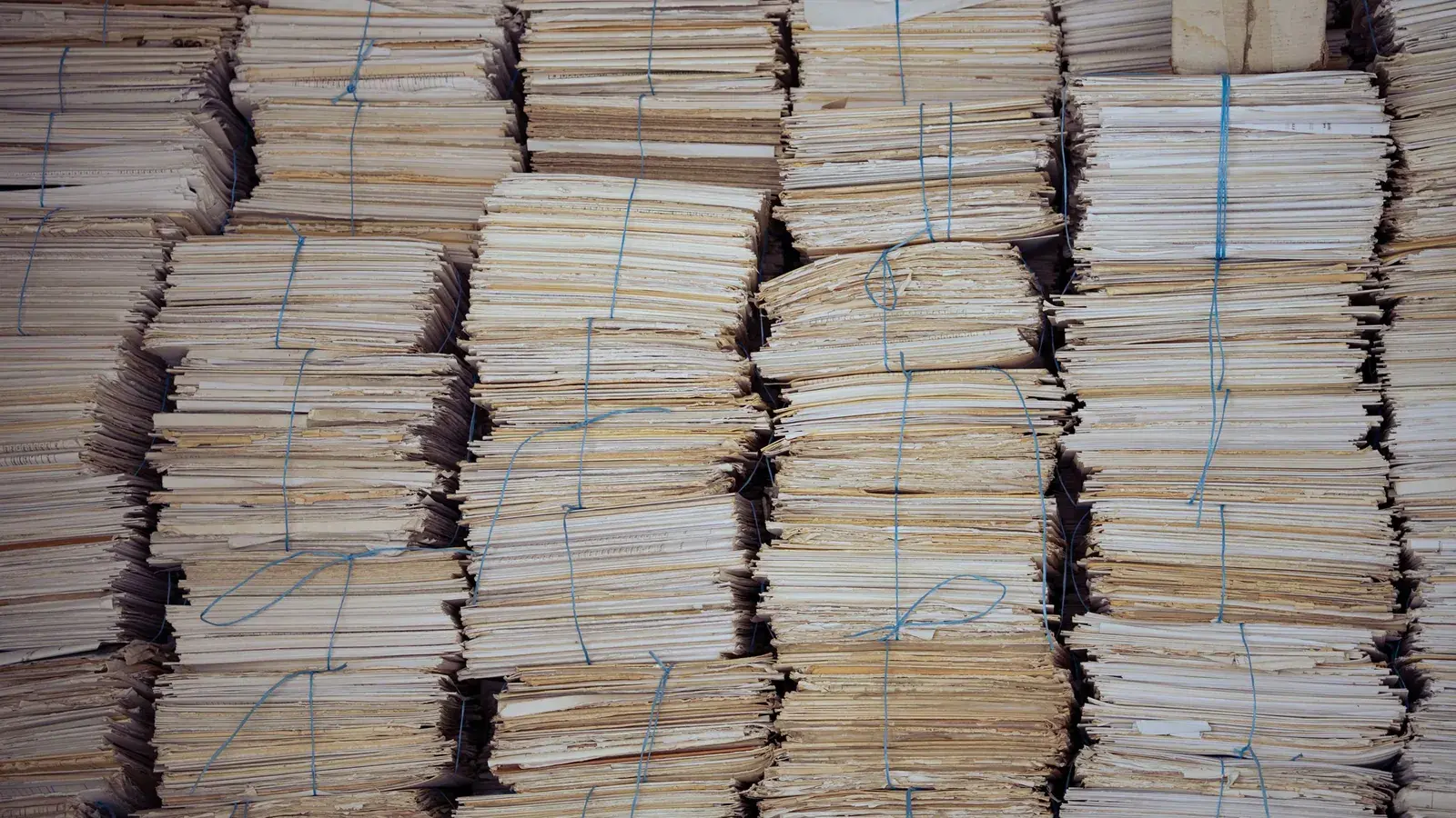 Stacks of paper files tied with string in an archive