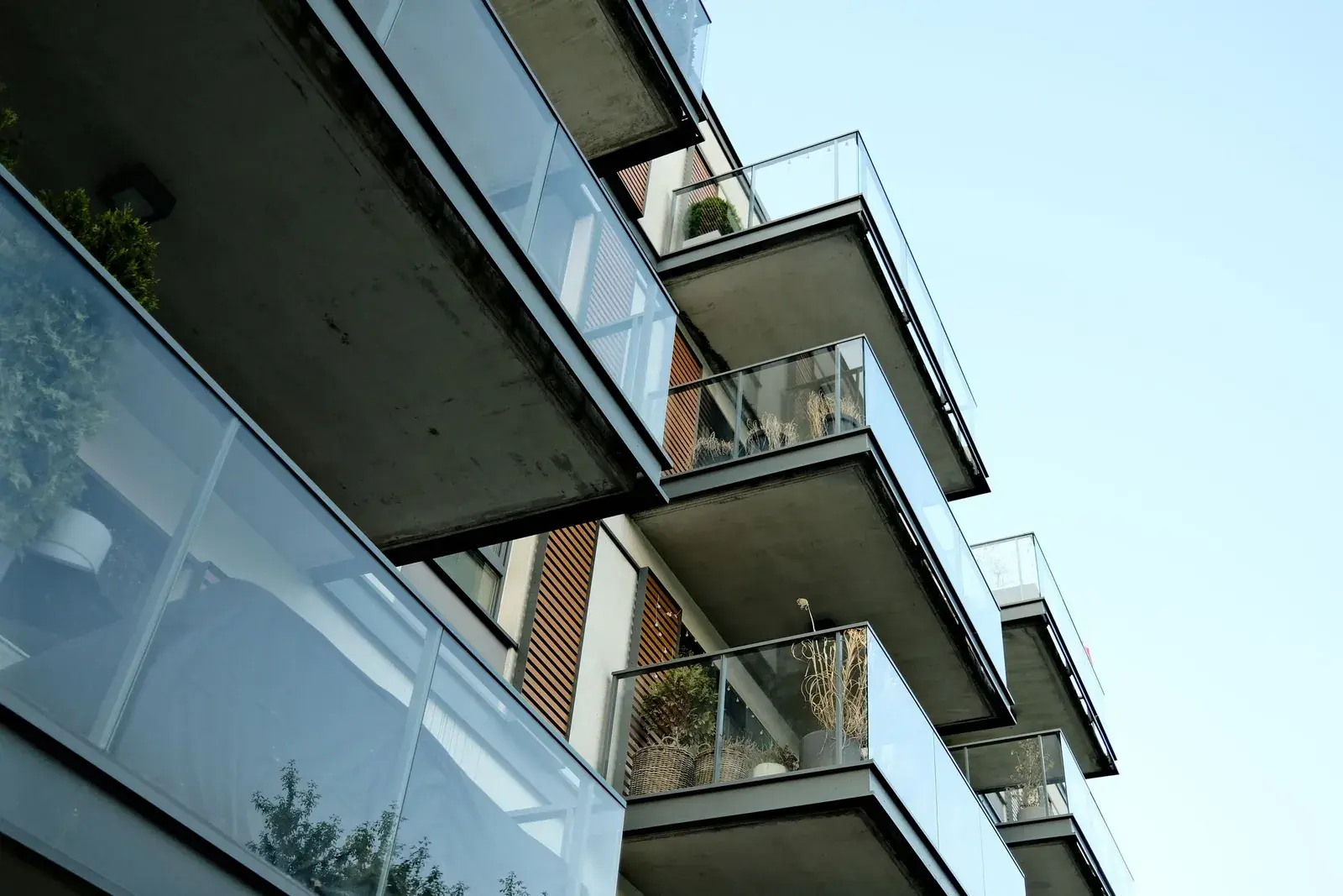 Glass balconies on a modern apartment building under a clear sky