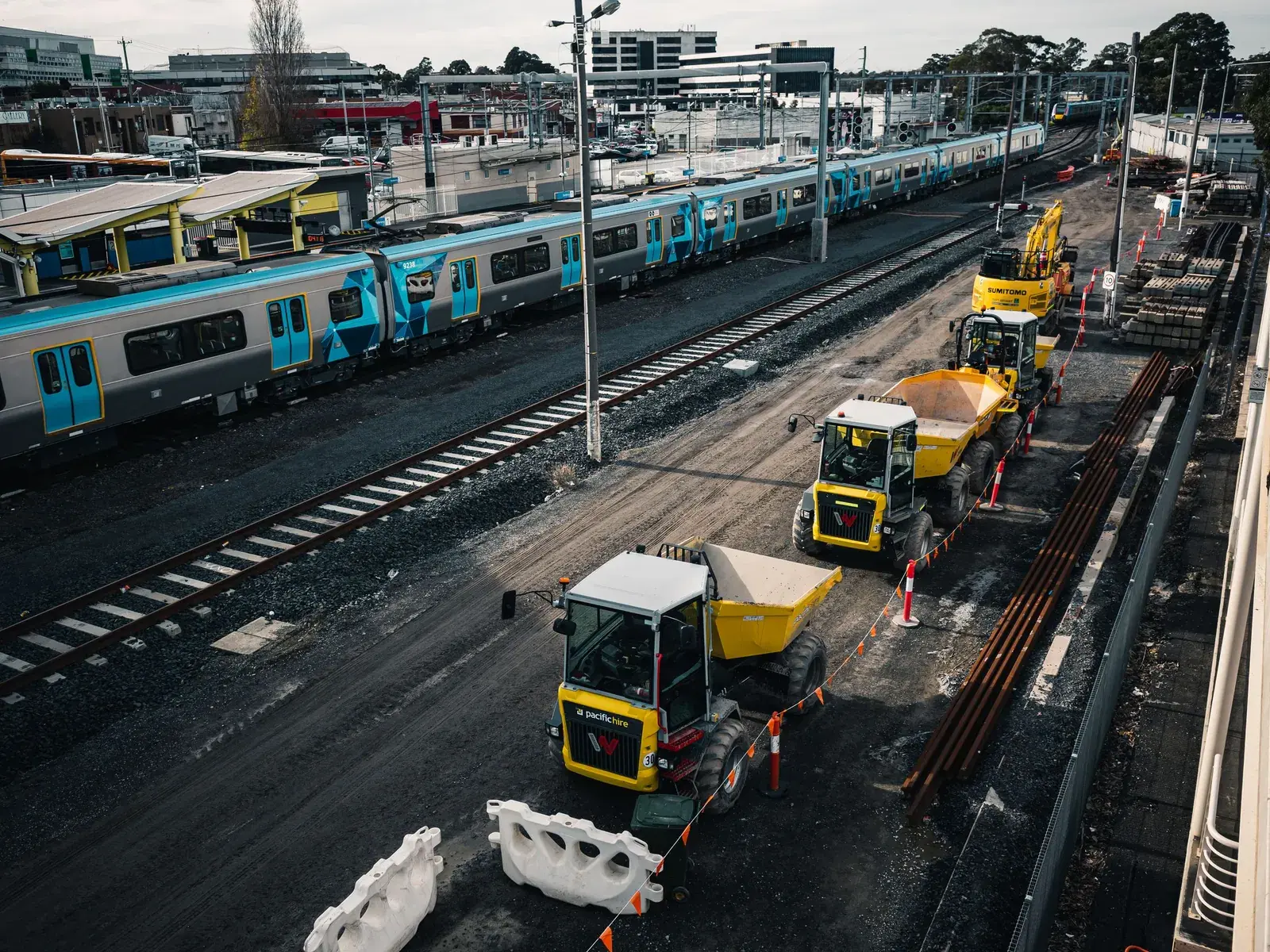 Makineri ndërtimi mbi binarë pranë një stacioni treni periferik