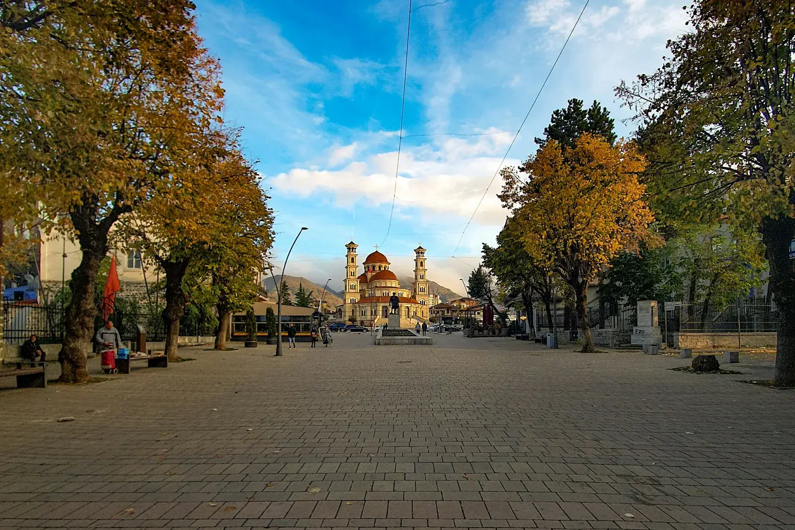 Shëtitorja e Korçës me pemë vjeshte që të çon te Katedralja Ringjallja e Krishtit