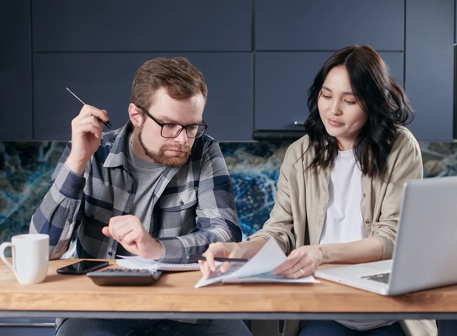 Couple working out their budget with a calculator and a laptop