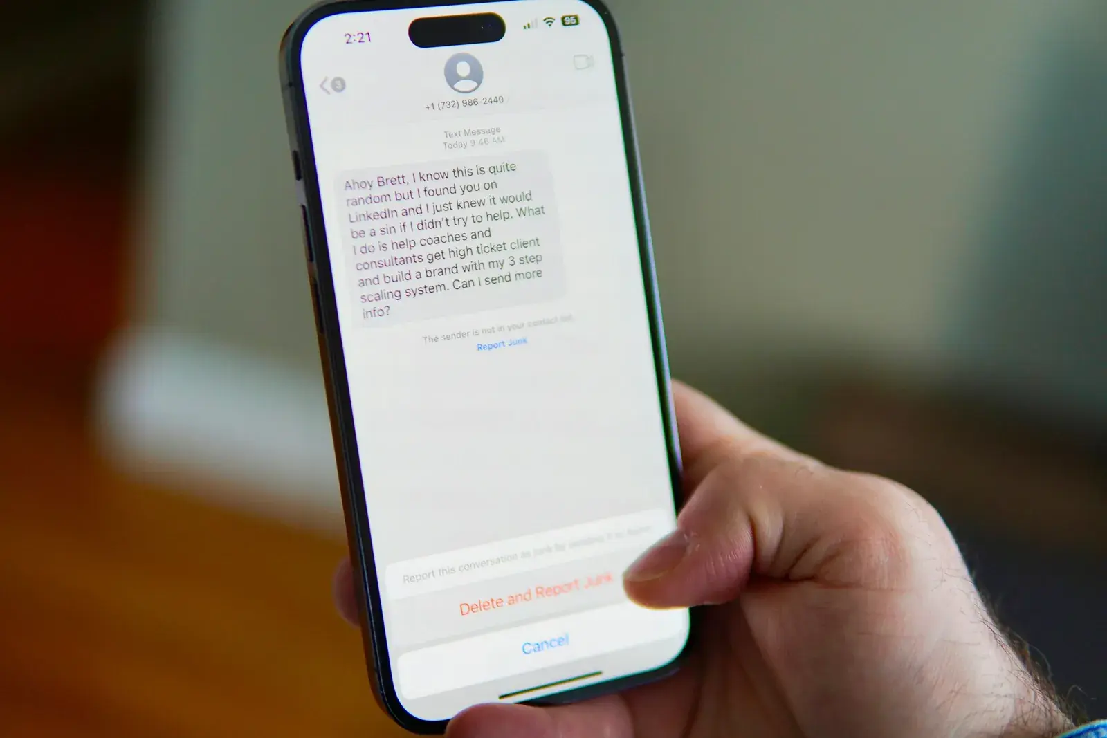 Telefono con un SMS da un numero sconosciuto e l’opzione per segnalarlo come indesiderato
