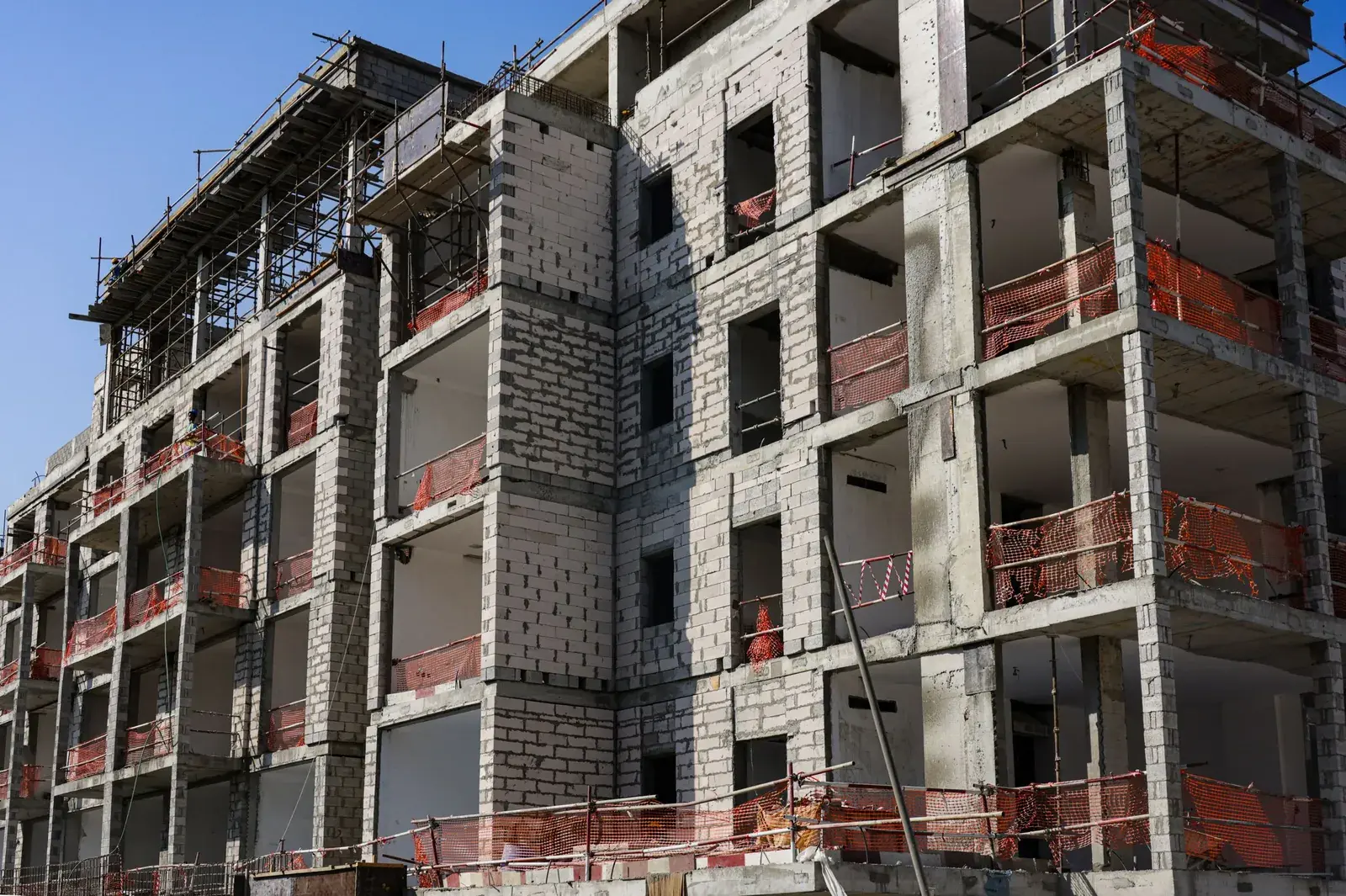 Apartment building under construction with block walls and scaffolding