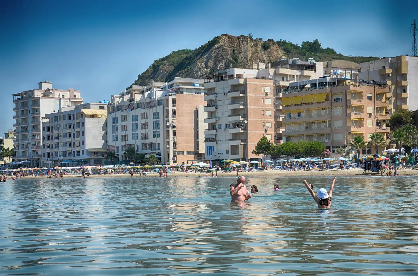 Apartment buildings on the beach at Shkëmbi i Kavajës, with the hill behind them