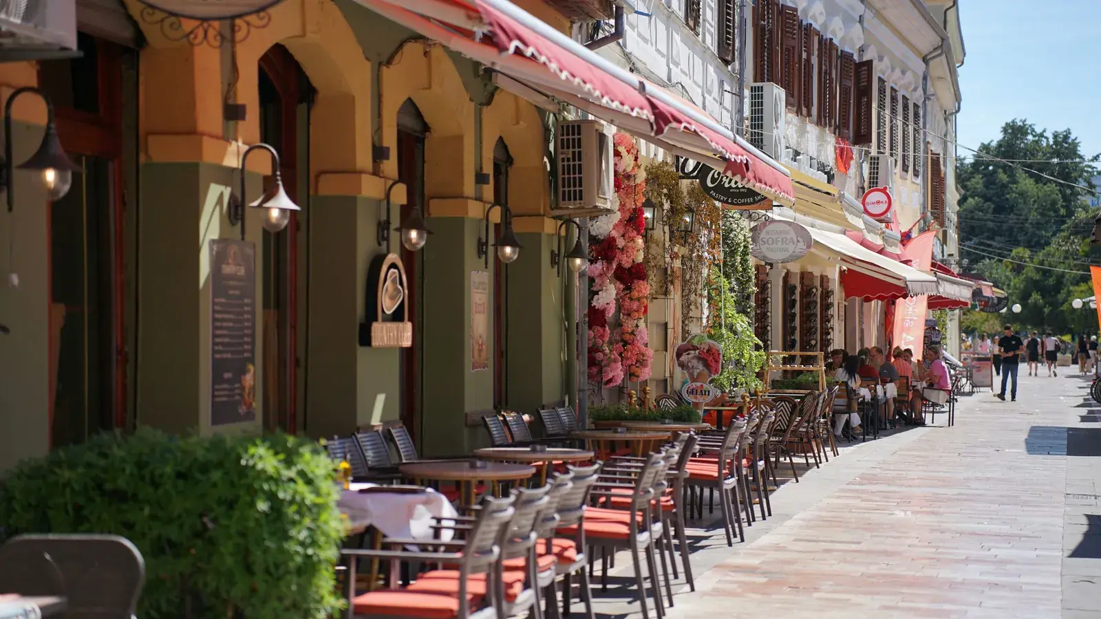 Pedestrian street in Shkodër with cafés and outdoor tables on a sunny day