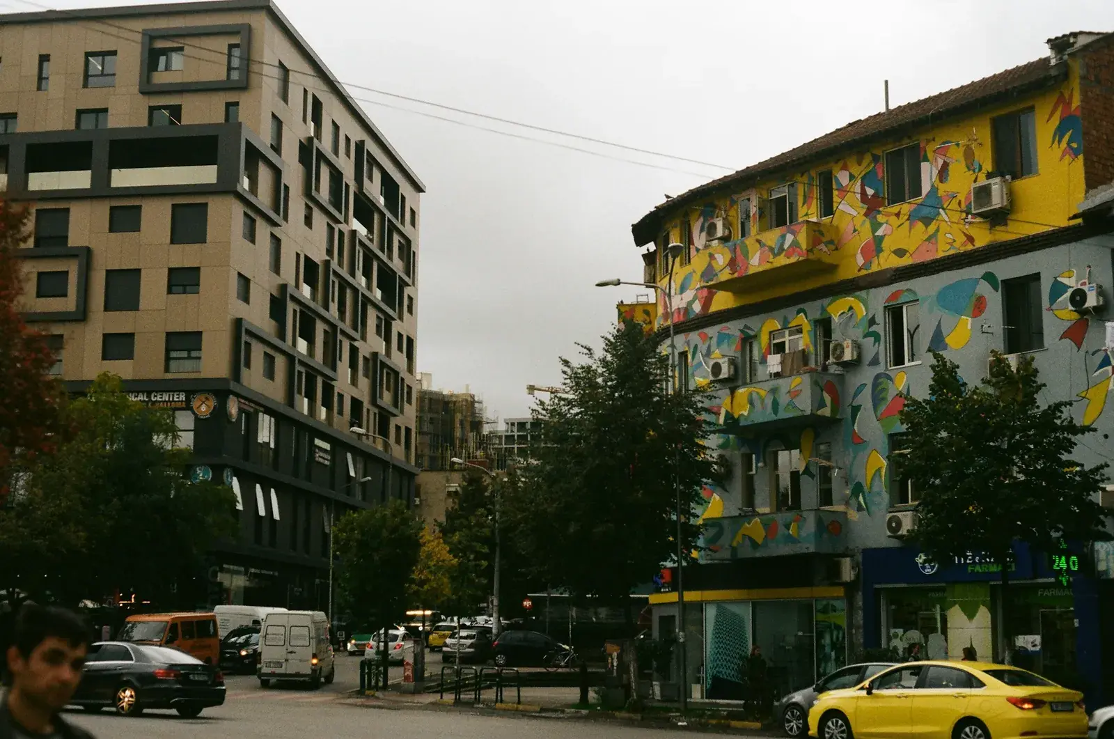 Makina të parkuara në një rrugë të Tiranës, mes pallateve të reja dhe të vjetra